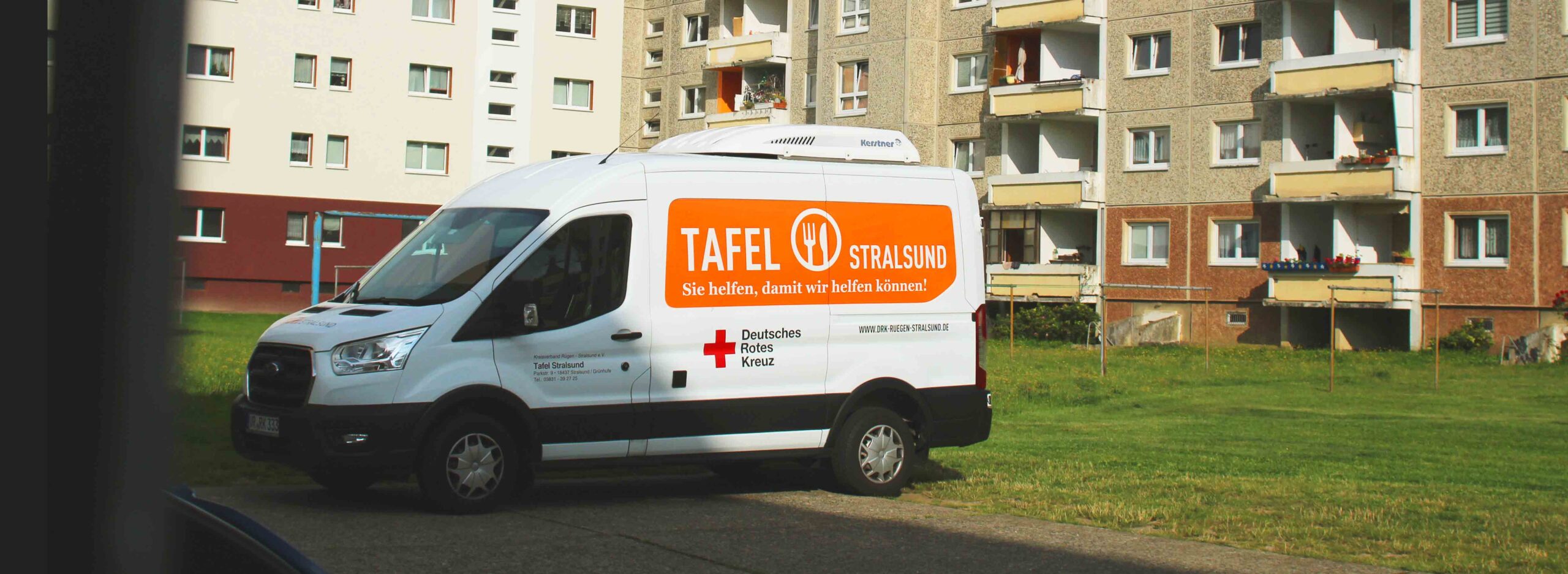 Kühlfahrzeug der Tafel Stralsund mit Logo auf der Motorhaube, das frische Lebensmittel für Bedürftige transportiert.