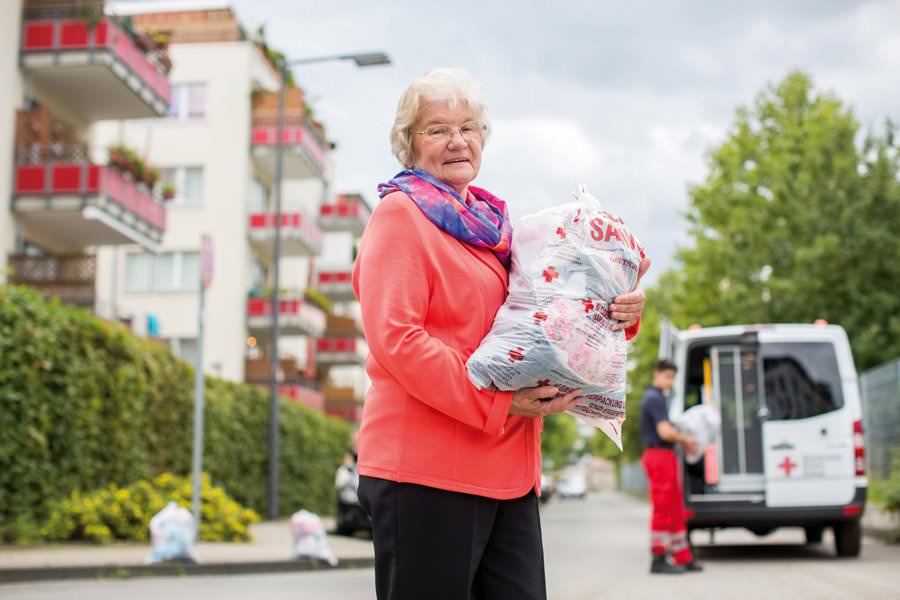 DRK-Mitarbeiter vor Altkleidercontainer. Rückbau der Sammelstellen wegen Pandemie.